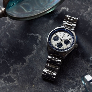 Horloge met metalen band en tachymeter op donkere achtergrond, close-up.