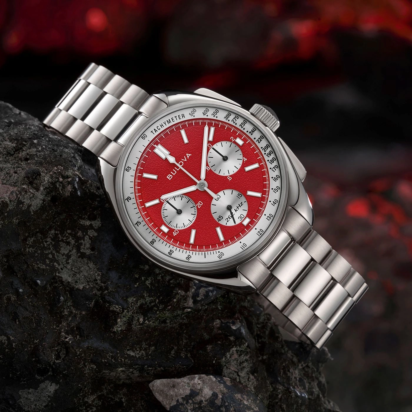 Rode Bulova-horloge met zilveren band op donkere steen, tachymeter, close-up.