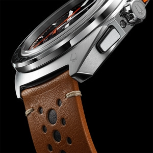 Close-up van een horloge met bruine leren band en zwarte achtergrond.