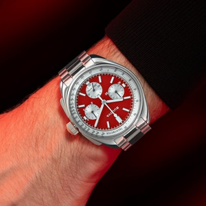 Horloge om de pols met rode wijzerplaat en zilveren band, Bulova.