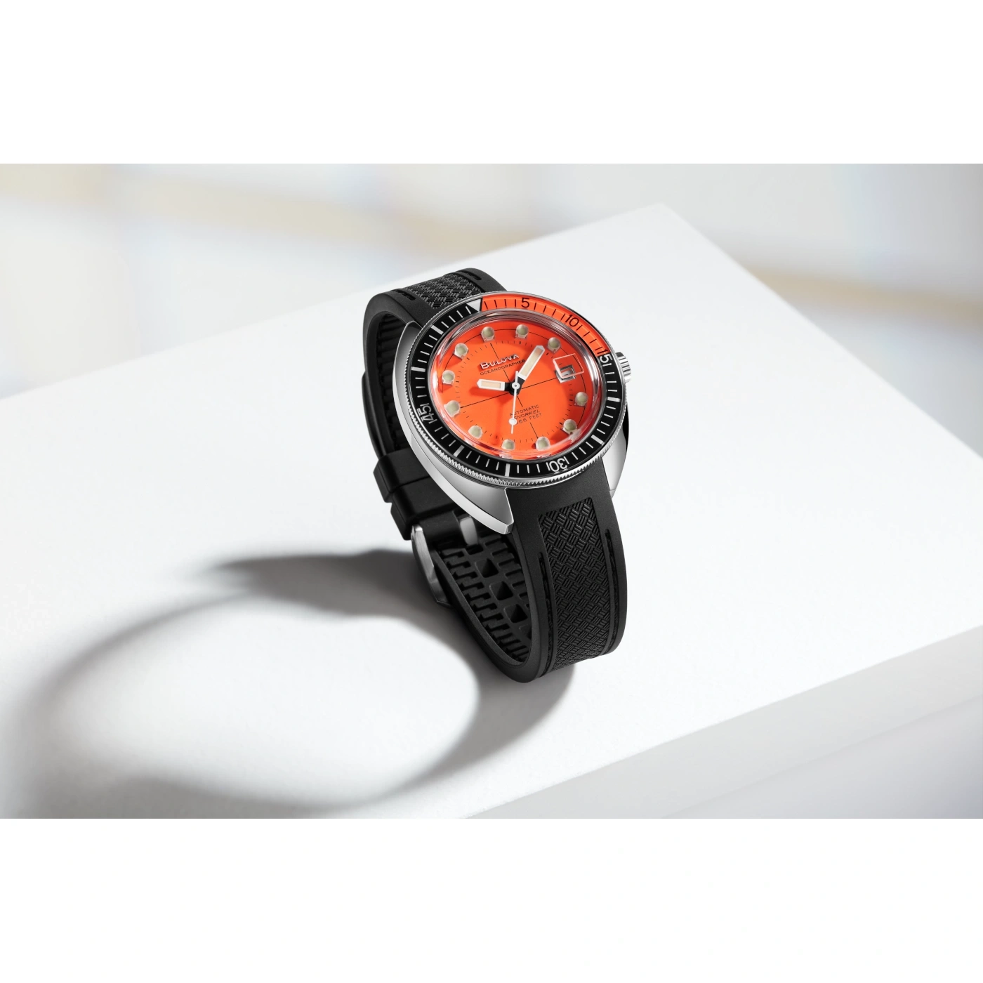 Horloge met oranje wijzerplaat en zwarte band op witte achtergrond