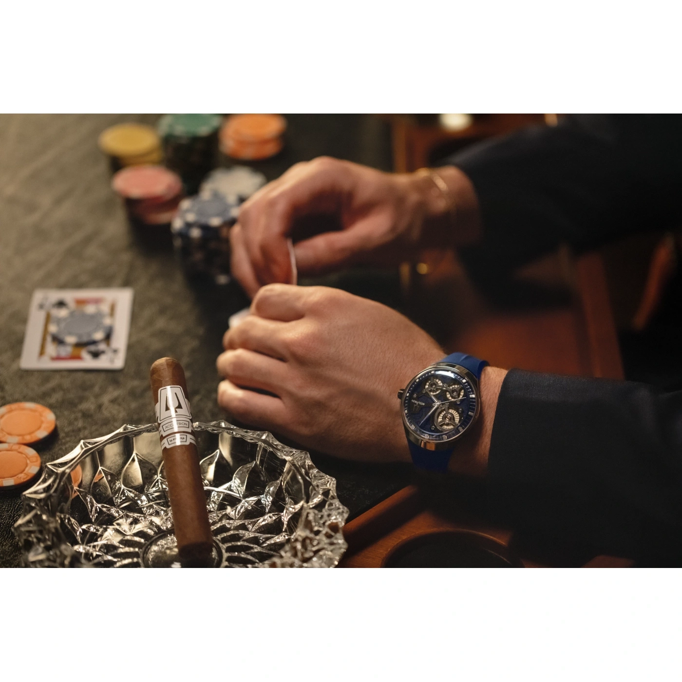 Man speelt poker met sigaar en horloge. Speelkaarten, chips en asbak.