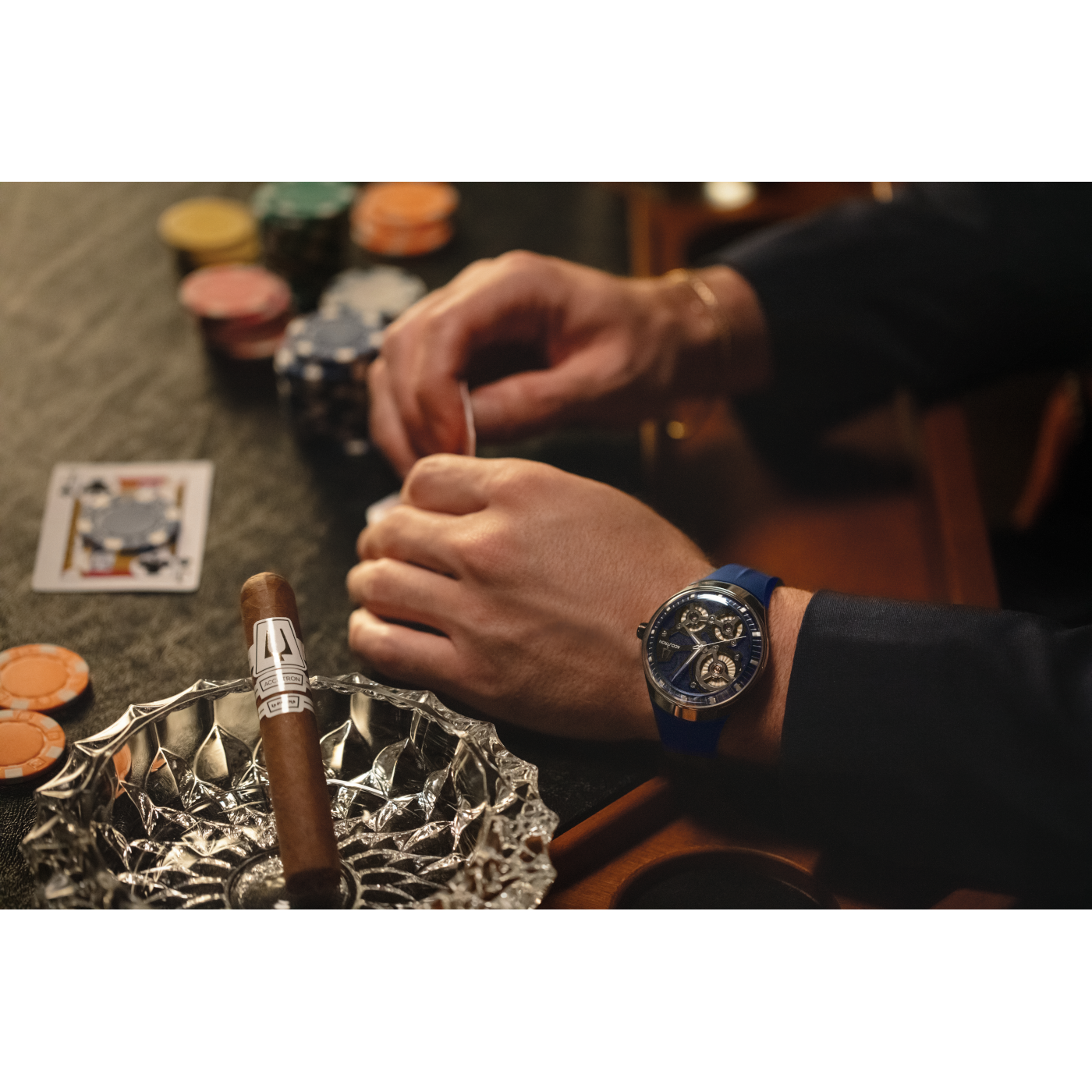 Man speelt poker met sigaar en horloge. Speelkaarten, chips en asbak.