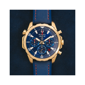 Gouden Bulova Marine Star horloge met blauwe wijzerplaat en leren band.