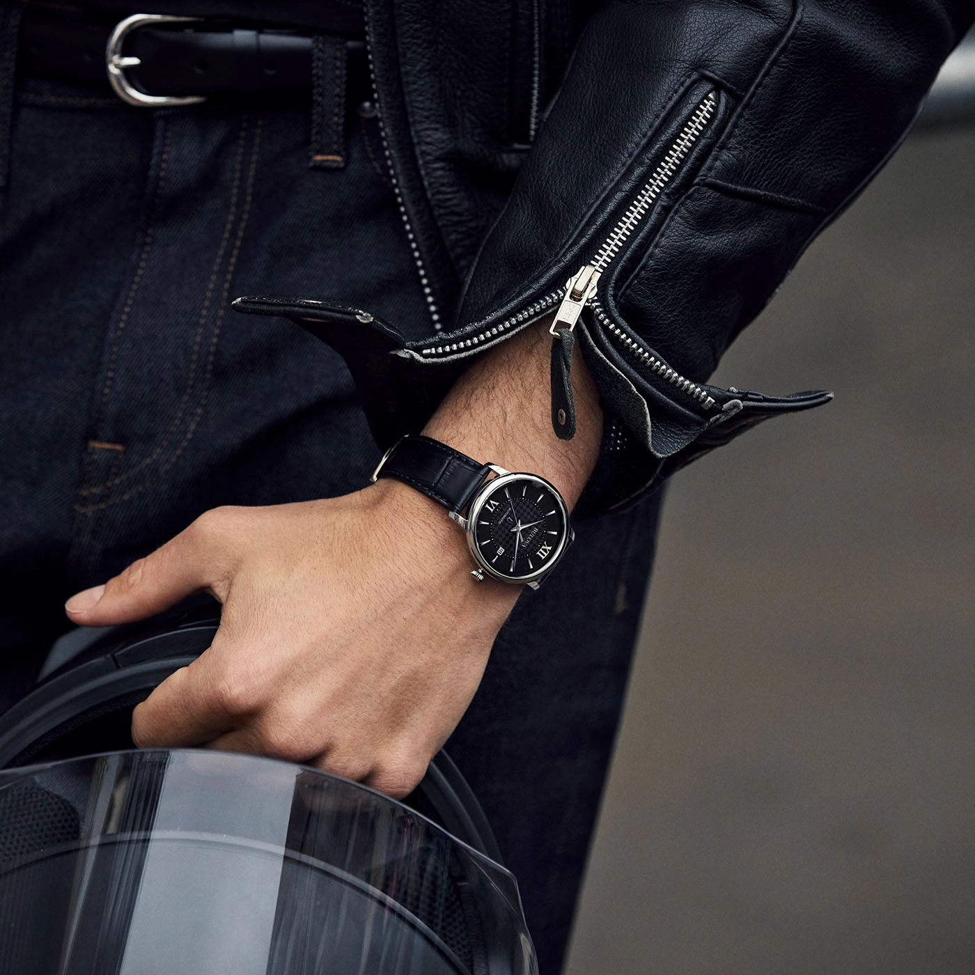 Man met horloge en leren jas houdt helm vast. Close-up.