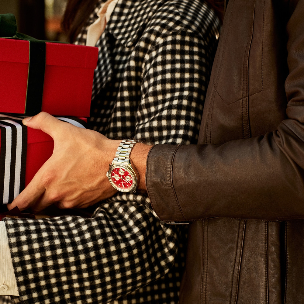 Man met horloge houdt cadeaus vast, vrouw in geruite jas, leren jas