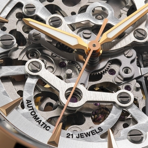 Close-up van een horloge met gouden wijzers en een ingewikkeld uurwerk.