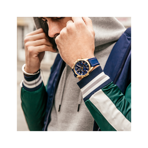 Man met horloge, hoodie en jas trekt de capuchon over zijn hoofd.