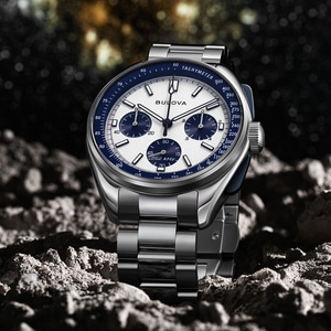 Bulova horloge op rotsachtige ondergrond met blauwe wijzerplaat en zilveren armband.