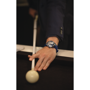 Man speelt pool, horloge om pols, blauw horlogebandje, pak, close-up