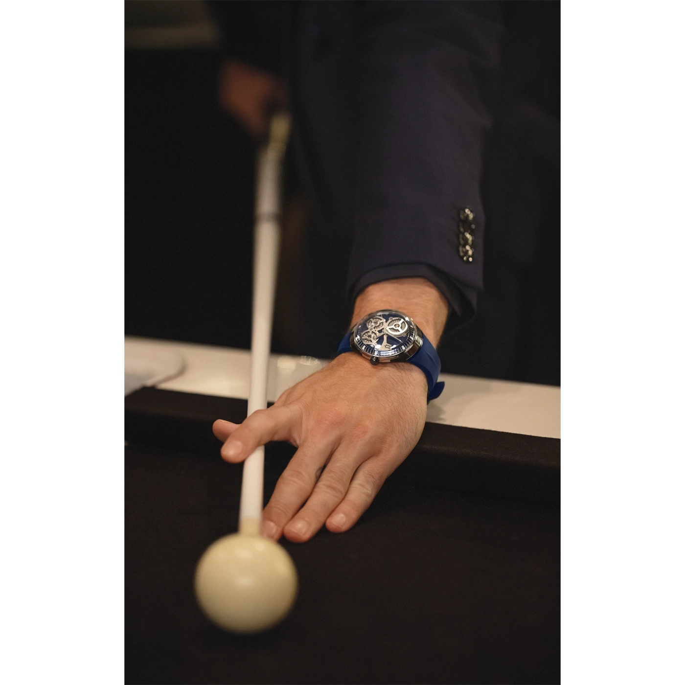 Man speelt pool, horloge om pols, blauw horlogebandje, pak, close-up