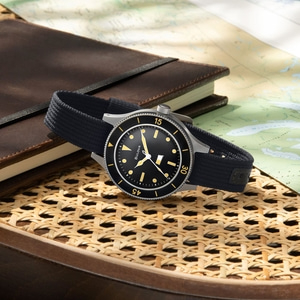 Horloge met zwarte wijzerplaat en band op kaart en notitieboek, close-up