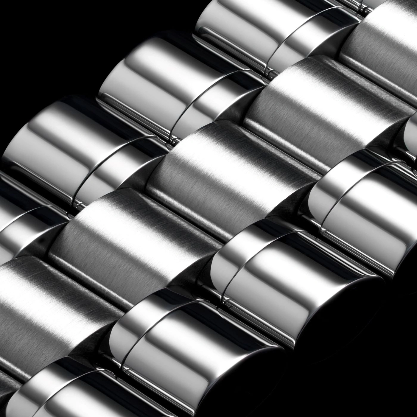 Close-up van glanzend metalen oppervlak met gebogen elementen en reflecties op zwart