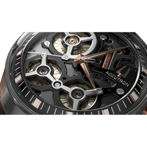 Close-up van een zwarte Accutron-horloge met roségouden accenten en complex uurwerk