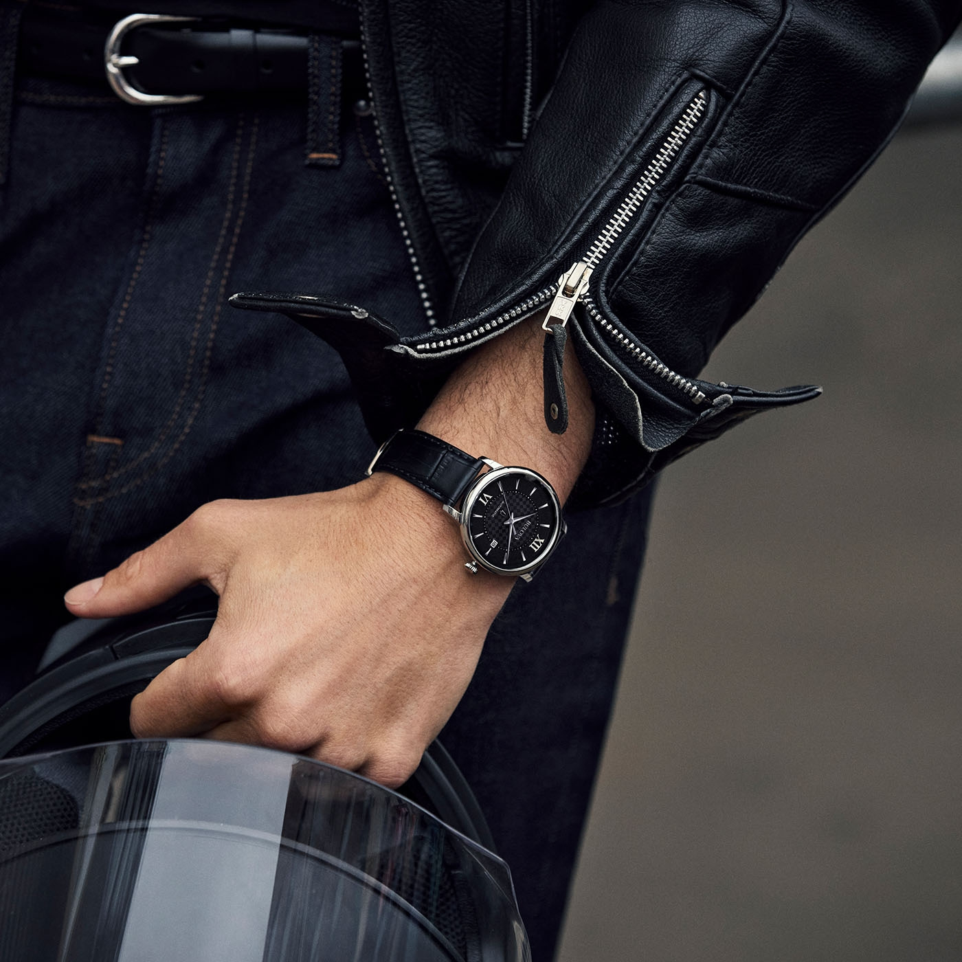 Man met horloge en leren jas houdt helm vast. Close-up.