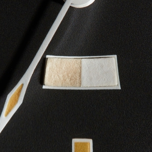 Close-up van een rechthoekig object met twee verschillende texturen op een zwarte achtergrond.