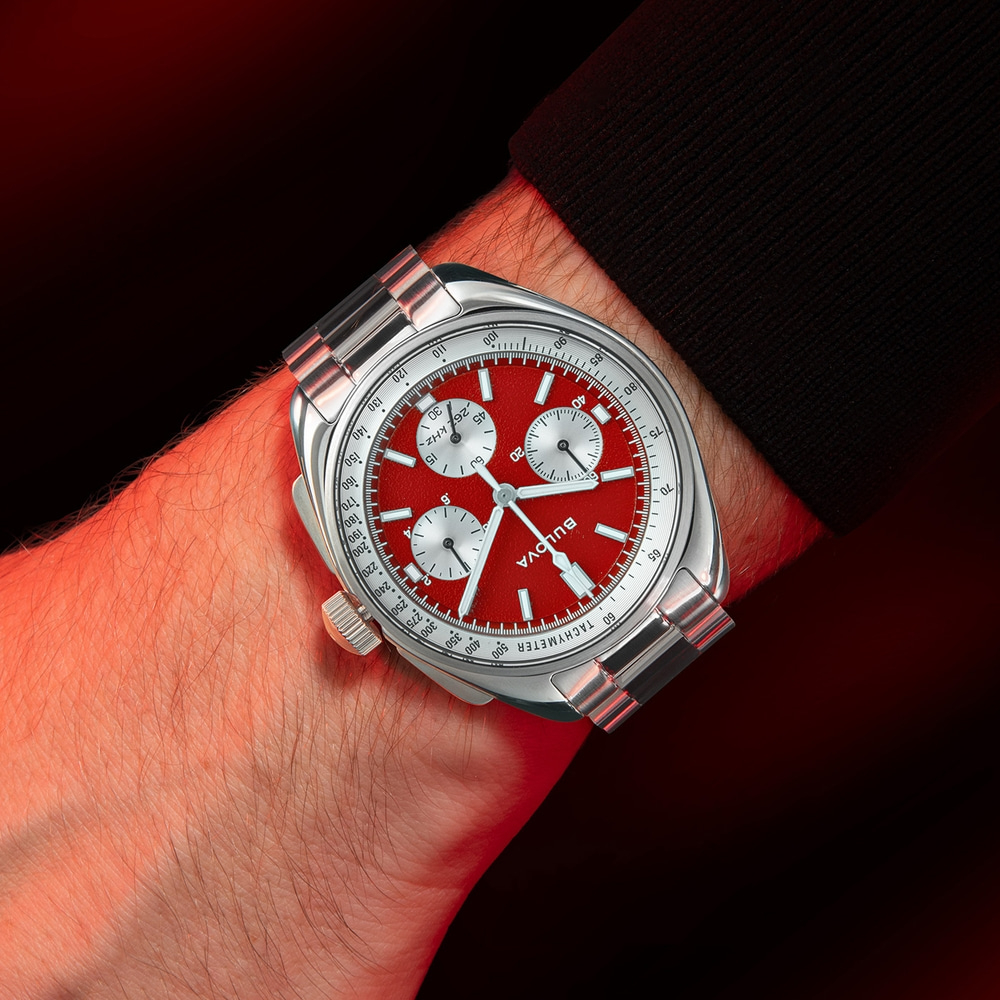 Horloge om de pols met rode wijzerplaat en zilveren band, Bulova.